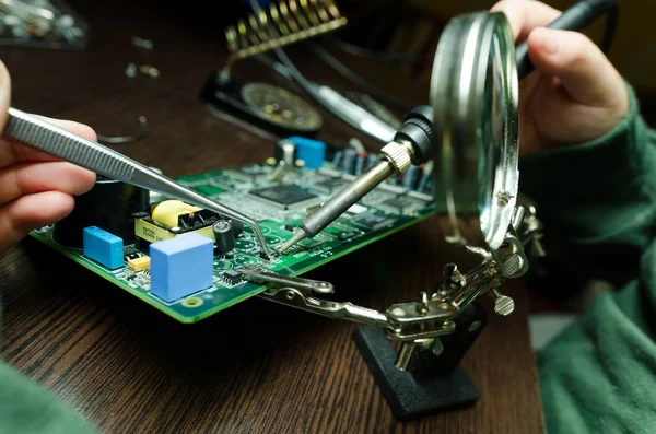 Reparación de hombres con lupa tablero electrónico —  Fotos de Stock