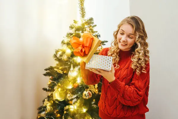 Girl is surprised by christmas gift box.