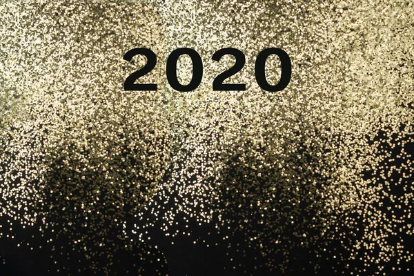 2020 year on golden shiny background of sparkles.