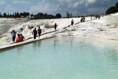 Pamukkale, Turkey - April 09, 2009: Unidentified tourists in the UNESCO World Heritage site, this natural place of interest contains hot springs and travertines, terraces of carbonate minerals left by the flowing water