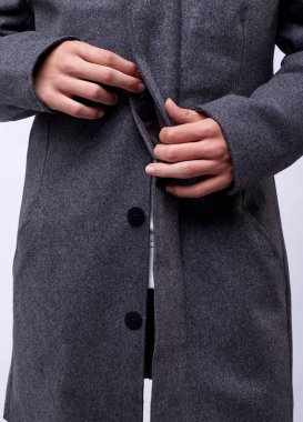 Gri kışlık montlu yakışıklı genç adam beyaz arka planda izole edilmiş..