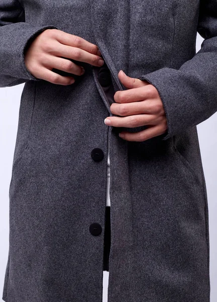 Gri kışlık montlu yakışıklı genç adam beyaz arka planda izole edilmiş..