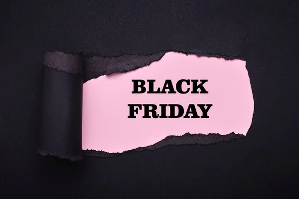 Black friday. Hole in the black paper. Torn. Pink paper background. Abstract background. — Stock Photo, Image