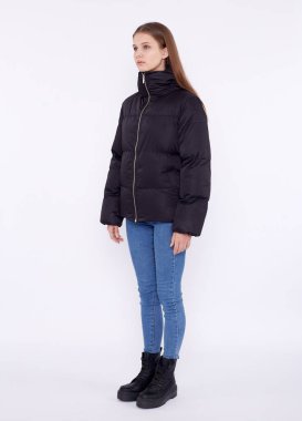 Siyah ceketli ve kot pantolonlu genç kız beyaz arka planda izole edilmiş..