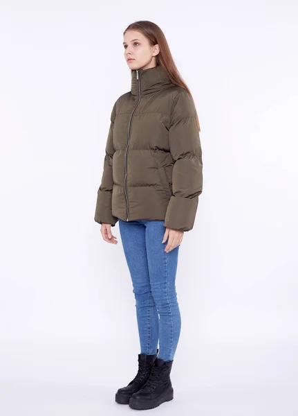 Young girl in a khaki down jacket isolated on a white background. — Stock Photo, Image