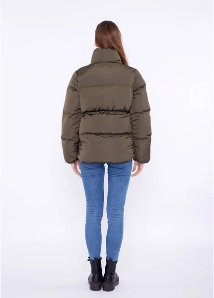 Young girl in a khaki down jacket isolated on a white background. — Stock Photo, Image