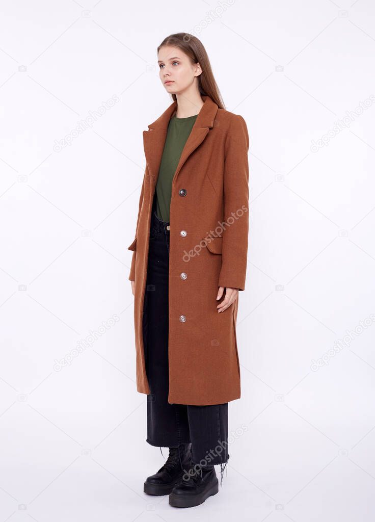 Beautiful fashion model in long brown coat isolated on white background