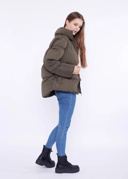 Chica joven en una chaqueta de plumón caqui aislado sobre un fondo blanco . — Foto de Stock