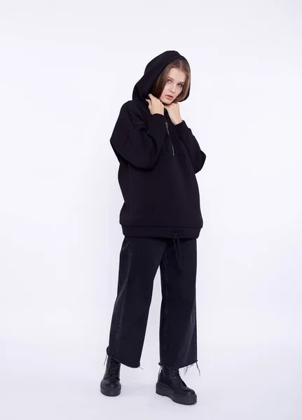Jong meisje draagt een witte en oversized zwarte lange hoody. Witte achtergrond — Stockfoto
