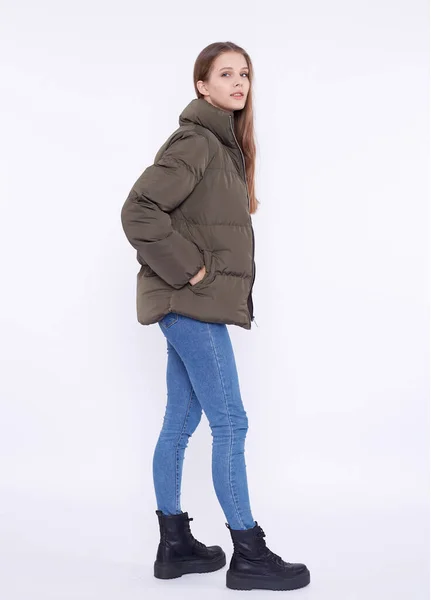 Young girl in a khaki down jacket isolated on a white background. — Stock Photo, Image