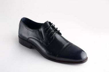 Beyaz arka planda ayakkabı bağcığı olan siyah adam deri ayakkabısı.