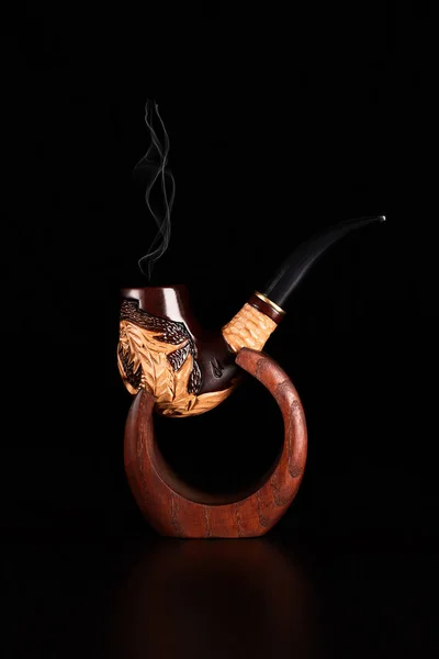 Табачная труба с дымом на черном фоне . — стоковое фото