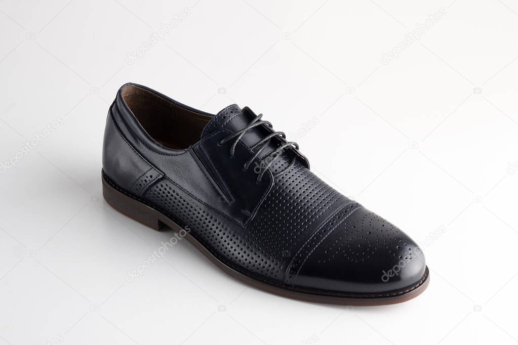 brown man's leather shoe with shoelaces on white background