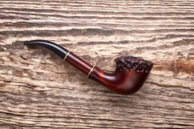 Eski ahşap arka planda tütün piposu.