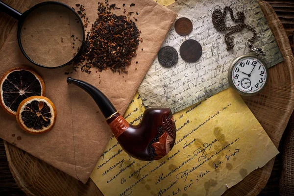Tuyau de tabac sur vieux fond en bois. Lettres anciennes, montres, pièces de monnaie et tabac . — Photo