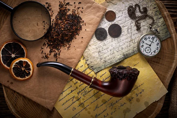 Tubería de tabaco sobre fondo de madera vieja. Letras, relojes, monedas y tabaco vintage . — Foto de Stock