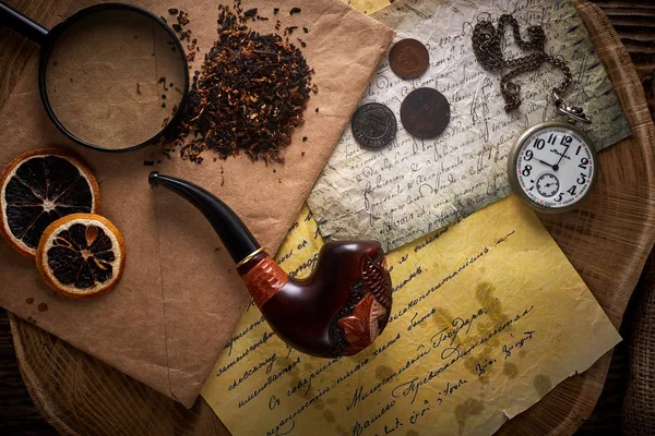 Poltava, Ucrania - 18 de noviembre de 2019: Tubería de tabaco sobre fondo de madera vieja. Letras, relojes, monedas y tabaco vintage . — Foto de Stock