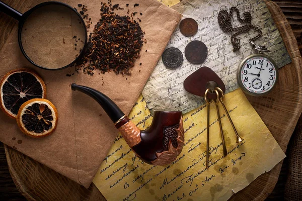 Poltava, Ukraine - 18 novembre 2019 : Tube de tabac sur un vieux fond en bois. Lettres anciennes, montres, pièces de monnaie et tabac . — Photo