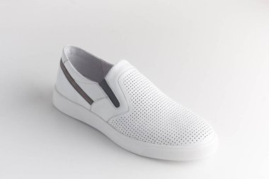 Beyaz arka planda spor beyaz deri ayakkabılar..