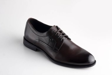 Beyaz arka planda ayakkabı bağcığı olan kahverengi adam deri ayakkabısı