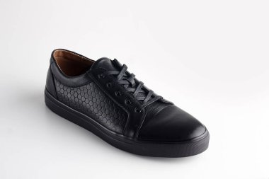 Beyaz arka planda ayakkabı bağcığı olan siyah adam deri ayakkabısı.