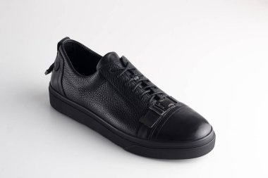 Beyaz arka planda ayakkabı bağcığı olan siyah adam deri ayakkabısı.