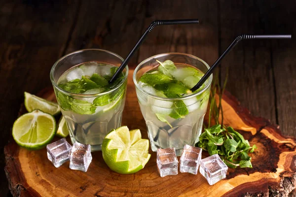 Fresh mojito in glasses with ice cubes on wooden table. — 스톡 사진