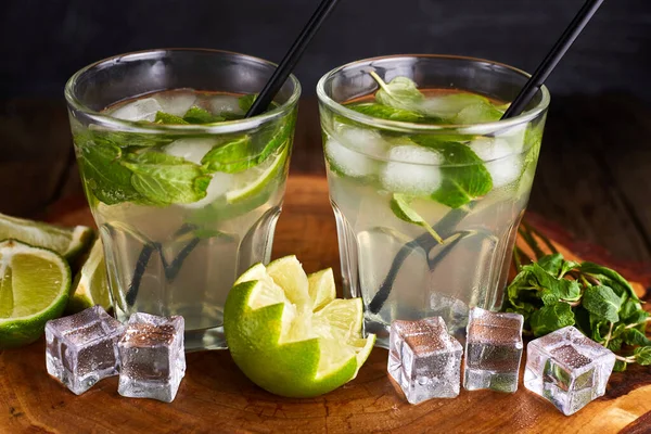 Fresh mojito in glasses with ice cubes on wooden table. — 스톡 사진