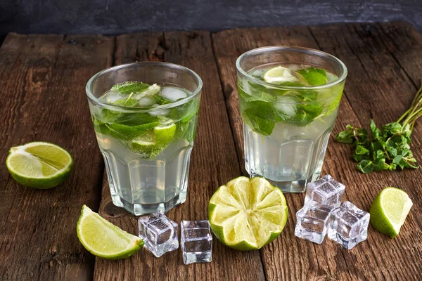 Fresh mojito in glasses with ice cubes on wooden table. — 스톡 사진