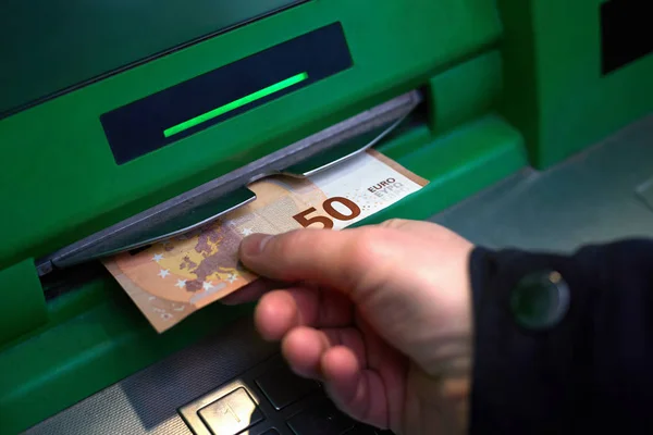 Hand man samtidigt ta ut sedlar 50 euro från en bankomat — Stockfoto