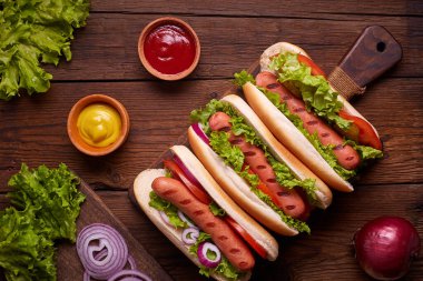 Turşulu sosisli, domates ve marullu ahşap arka planda. Üst görünüm