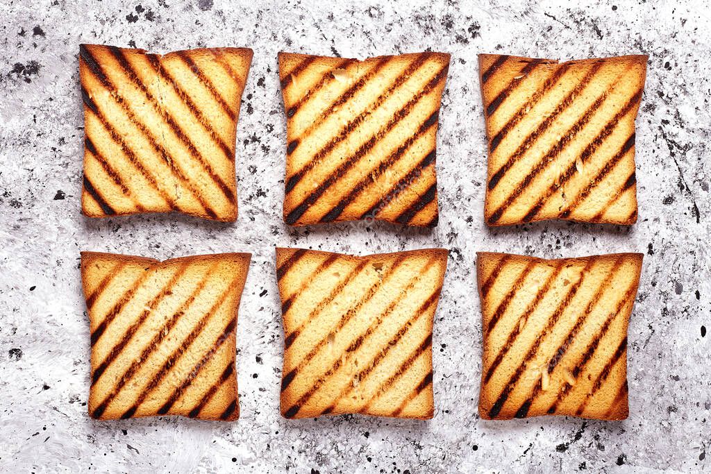 Set of six grilled slices toast bread on grey concrete background.