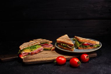Tabakta dört sandviç. Koyu arkaplan.