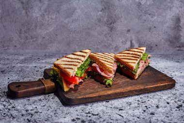 Beton zeminde sandviç, domates, marul ve sarı peynir..