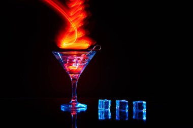 Uzun pozlu neon martini bardağı. Kırmızı kulüp ışıkları.