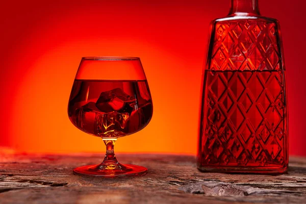 Szklanka Whisky Butelką Drewnianym Stole Czerwony Odcień Atmosfery Czas Relaksu — Zdjęcie stockowe