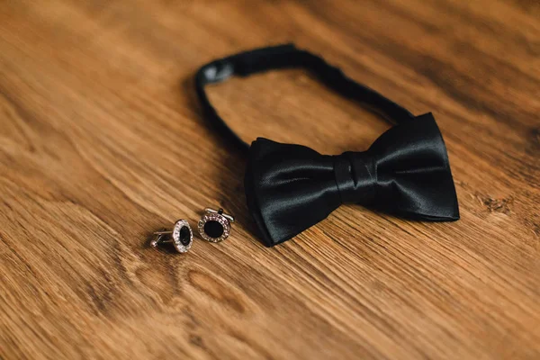 güzel siyah papyon ve ahşap arka plan üzerinde kol düğmeleri