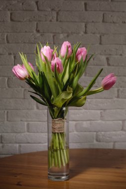 Lale beyaz tuğla ile zanaat iplik (sicim rewinded arka planda Pembe buket)