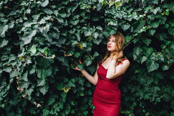 Yeşil sarmaşık bir arka plan üzerinde zarif, güzel kız.