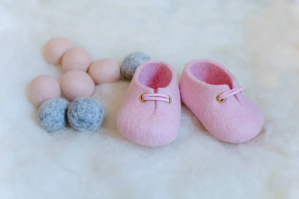Hand-made shoes from merino wool pink in the background of wool.