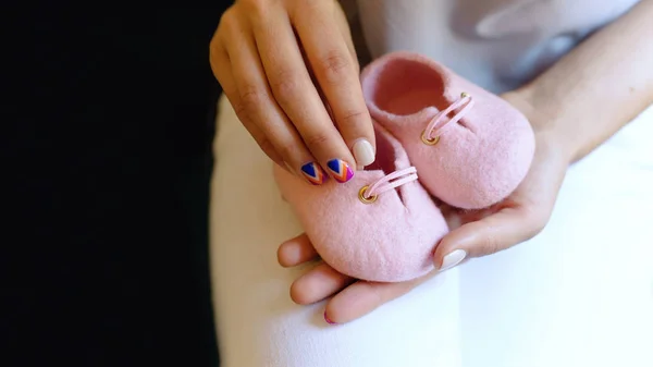 女の子の手にメリノ ウールのピンクの手作り靴 ストック写真