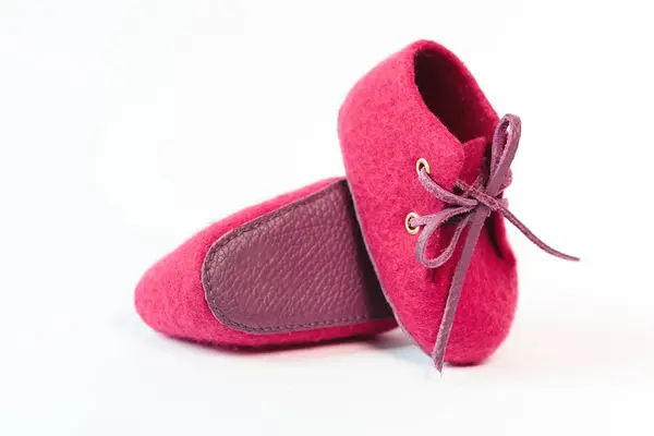 白色背景的美利奴羊毛制成的粉红色手工婴儿鞋 — 图库照片