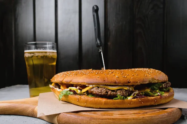 Büyük hamburger ve bira bir ahşap stand.