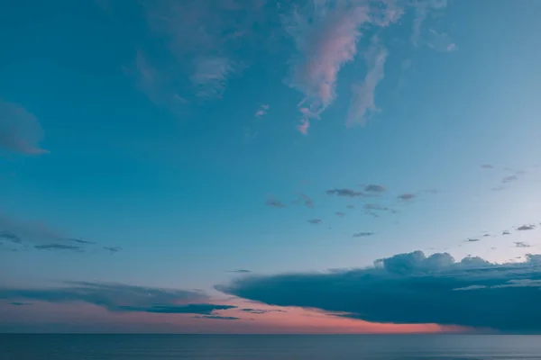 Sunset with clouds and turquoise blue and orange sky with the sea in the background. Twilight. Beautiful and magical sunset.Inspirational calm sea with sunset sky. Meditation ocean and sky background.