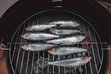 Kömür ızgarasında taze çiğ sardalyalar hazır. Sıcak kömürde ızgara sardalya. Sağlıklı gıda konsepti. Akdeniz mutfağı. İspanyol ve Portekiz sahillerinin tipik yemekleri. Üst görünüm.