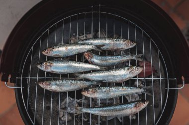Kömür ızgarasında taze çiğ sardalyalar hazır. Sıcak kömürde ızgara sardalya. Sağlıklı gıda konsepti. Akdeniz mutfağı. İspanyol ve Portekiz sahillerinin tipik yemekleri. Üst görünüm.