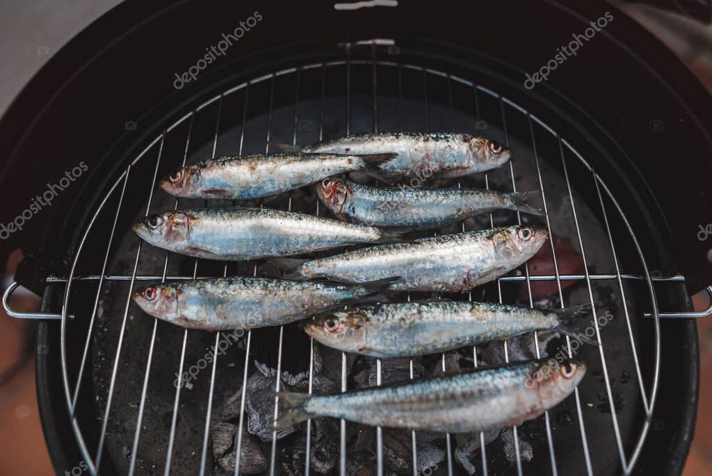 Sardinas frescas crudas preparadas en la parrilla de carbón. Sardinas a