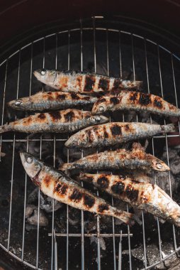 Barbeküde taze ızgara sardalya. Izgara yemek. Sıcak kömürde ızgara sardalya. Sağlıklı gıda konsepti. Akdeniz mutfağı. İspanyol ve Portekiz sahillerinin tipik yemekleri. Dikey fotoğraf.