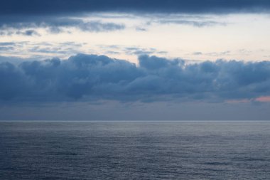 Bulutlu gökyüzü ve ufukta deniz.