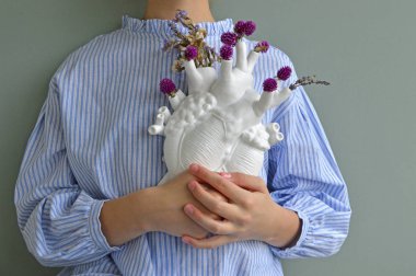 Kalp şeklinde porselen vazo bir kızın elinde.